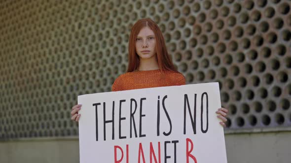 Teen Girl Posing on Street with There in No Planet B Banner