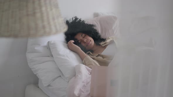 Slim Young Woman Sleeping in Bedroom in the Morning with Laptop on Bed