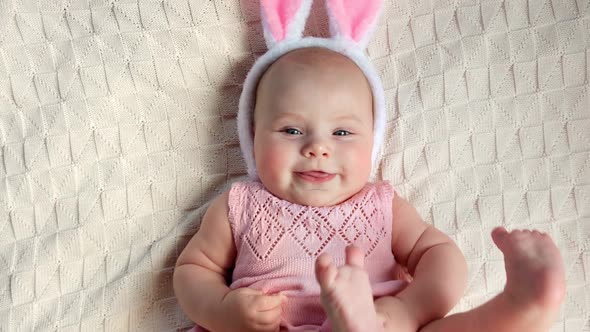 Funny Little Child is Wearing Bunny Ears on Cozy Background