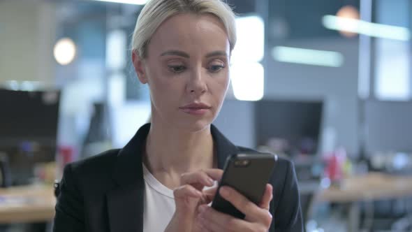 Portrait of Cheerful Businesswoman Using Smartphone