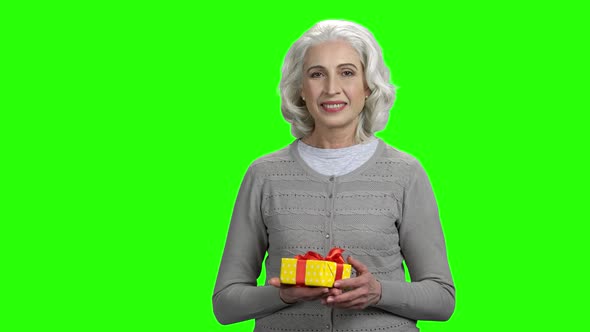 Portrait of Senior Woman Presenting Gift Box