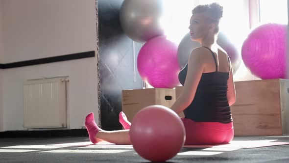 Pregnant Woman Performing Stretching Exercise on Fitness Ball in Office