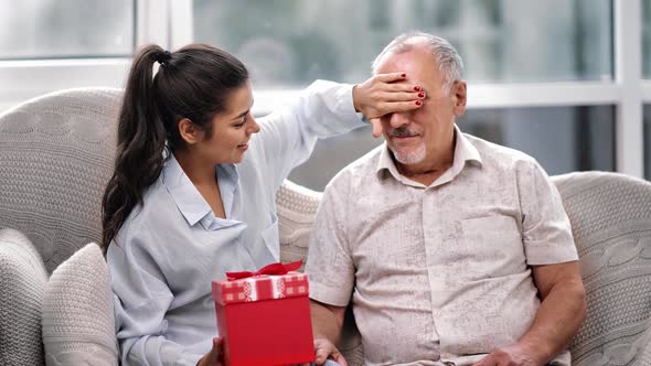 Happy Daughter Granddaughter Making Gift Surprise to Father Grandfather