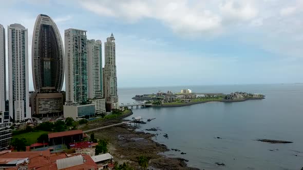 Aerial drone footage of famous building in Panama City  in front of an artificial island