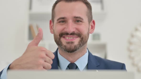 Positive Businessman with Laptop Showing Thumbs Up