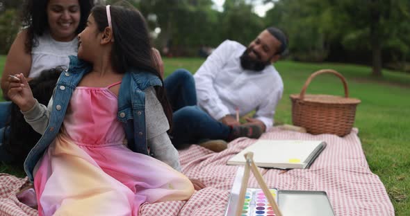 Indian parents having fun at city park painting with their children