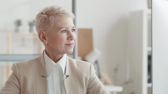 Mature Caucasian Business Lady Smiling Confidently in Office