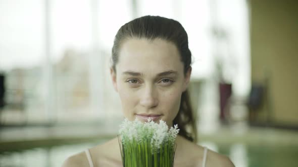 Young woman smelling fresh flowers, portrait