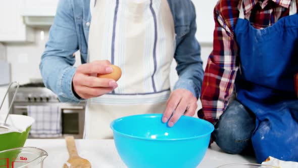 Father teaching his son how to make cupcake