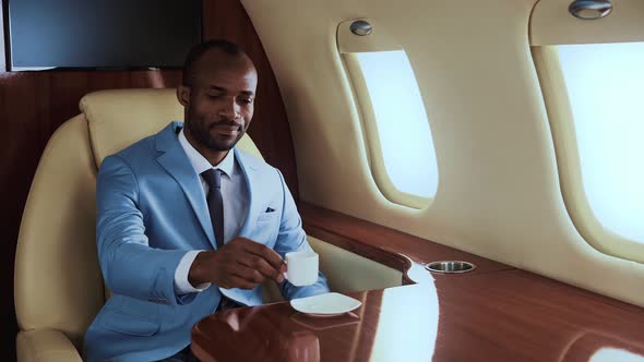 Successful entrepreneur drinking espresso on his private jet