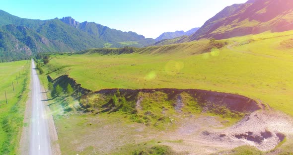 Aerial Rural Mountain Road and Meadow at Sunny Summer Morning. Asphalt Highway and River.