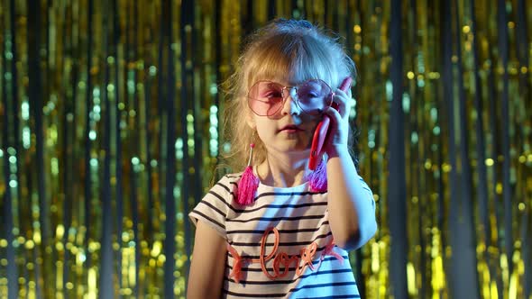 Girl in Futuristic Glasses Talking on Mobile Phone with Friend in Night Club with Neon Blue Light