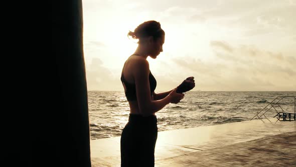 Athletic Woman Getting Her Fists Ready for the Boxing Gloves By Wrapping Bandage Around Them