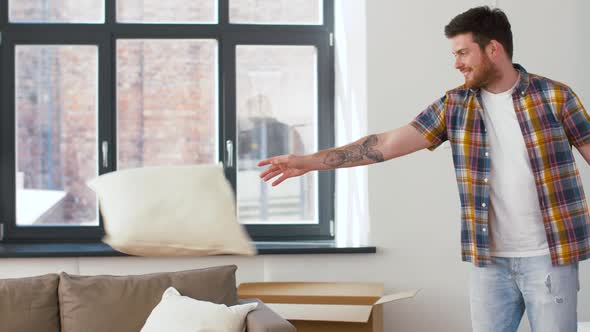 Man Dropping Pillows and Jumping To Sofa at Home