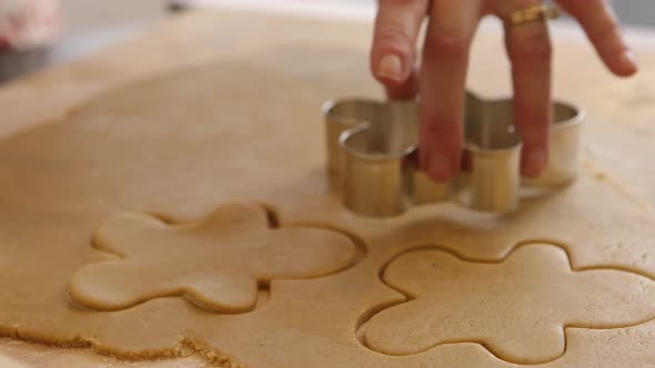 Cutting out gingerbread men cookies alt