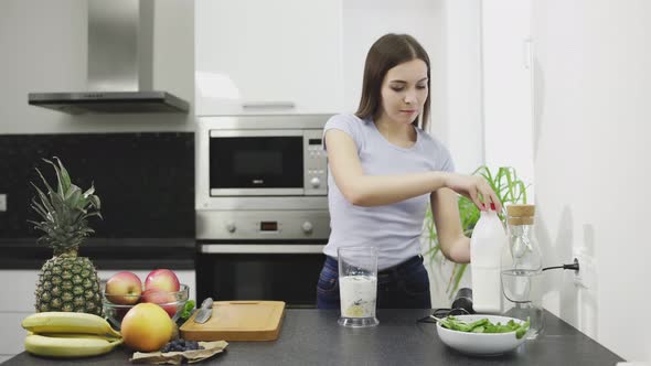 Beautiful Young Woman Is Making the Smoothie of Cocktail with Milk in Blender