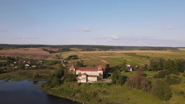 Aerial Drone Shot of Historic Castle on Hill Near Lake Medieval Architecture and Cultural Landmark