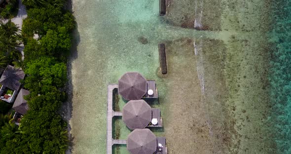 Luxury birds eye tourism shot of a sandy white paradise beach and turquoise sea background in colour