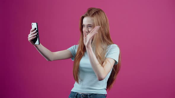 The Redhaired Young Woman with Blue Eyes Participates Exalted in a Video Call Where She Transmits