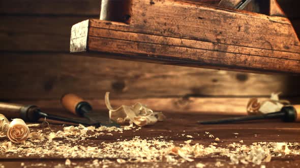 A Planer Falls on a Wooden Table with Sawdust
