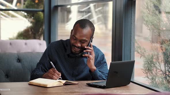 Businessman Working Remotely with Laptop at Cafe