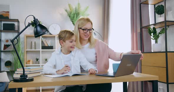 Mother Checking Online Results of School Test while Hepling with This Task Her Teen Son