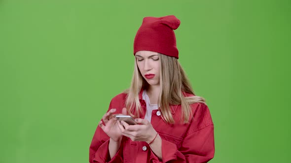 Girl Looks at the Pictures in the Phone and Shows a Thumbs Up. Green Screen. Slow Motion