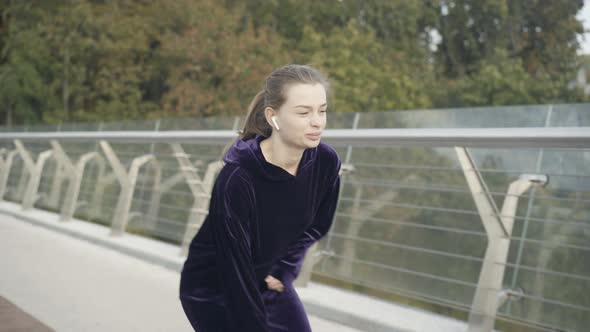 Young Female Runner Having Knee Pain As Jogging Outdoors in the Morning