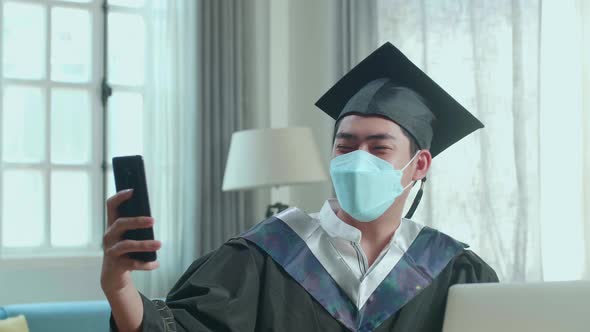 Man Wearing Protection Mask, Showing A University Certificate During An Online Video Call At Home alt