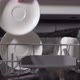 Young Woman in the Kitchen Opens the Dishwasher Loads and Takes Out Dishes - VideoHive Item for Sale