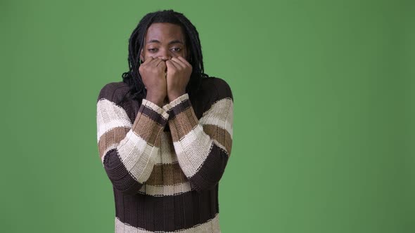 Young Handsome African Man with Dreadlocks Against Green Background