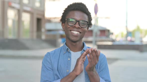 Young African Man Clapping in Appreciation Outdoor