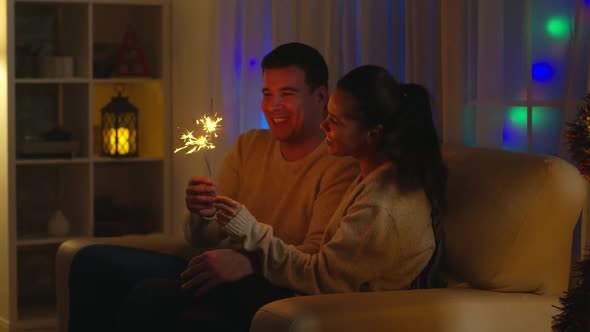 Romantic Young Couple Holding Fireworks