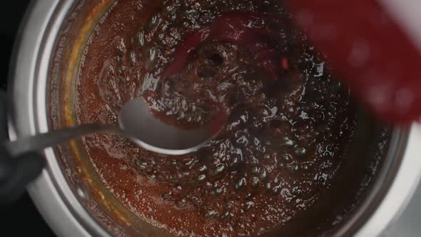 Tabletop Slow Motion Video: Chef Adds Mashed Strawberriy To the Boiling Caramel in Metal Bowl