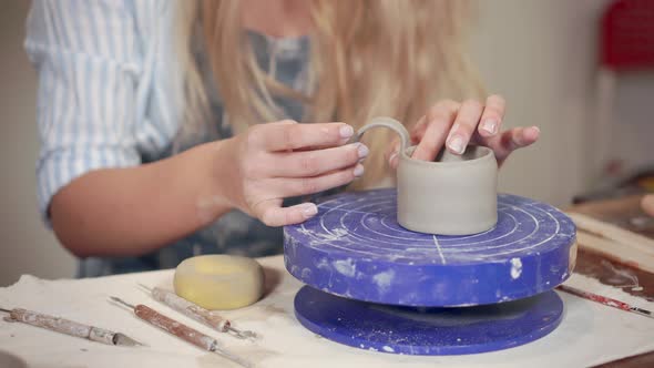 Ceramist Woman Is Fixing Handle To Clay Cup in Workshop, Close-up