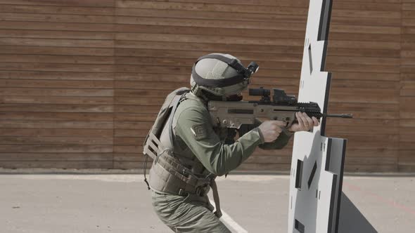 Slow motion of soldier shooting automatic rifle in a range alt