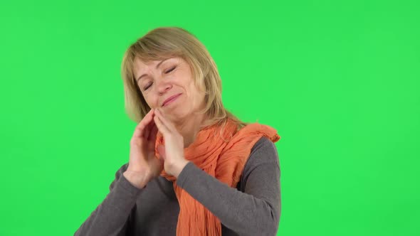 Portrait of Middle Aged Blonde Woman Is Keeping Palm Together and Asking for Something. Green Screen