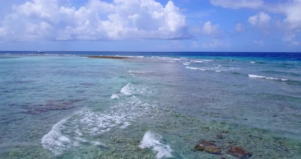 Wide angle above tourism shot of a paradise sunny white sand beach and aqua blue ocean background in