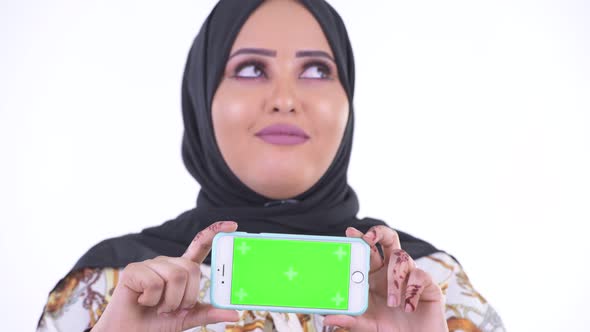 Face of Happy Young African Muslim Woman Thinking While Showing Phone