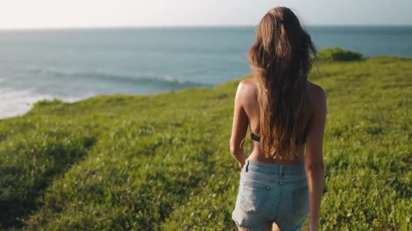 Woman Bokeh Asia Grass Beach on Rocks Shore at Ocean Water Bay Scene Wild Sumba Island Indonesia