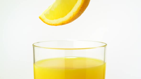 Sliced orange falling into orange juice, Slow Motion