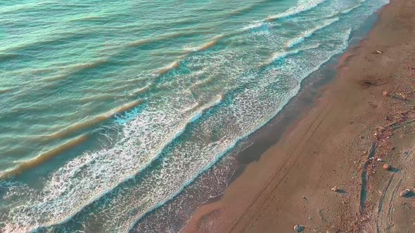 Drone view of the beautiful waves on the sandy beach,