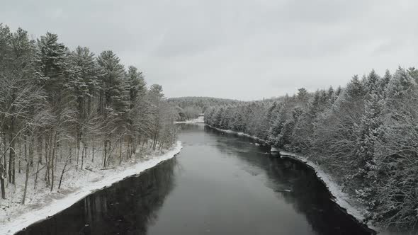 Snowy banks along Piscataquis river. Maine. USA. Aerial zoom out