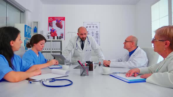 Doctor Discussing with Medical Staff in Hospital Conference Room