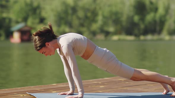 Beautiful Woman Practicing Yoga on Wooden Dock on Lake