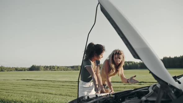 Closeup of Attracrive Interracial Friends Wearing Sexy Shorts Looking Under the Hood of Broken Auto