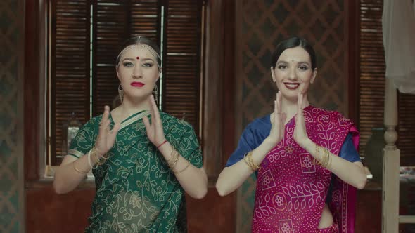 Pretty Women Connecting Hands in Namaste Greeting