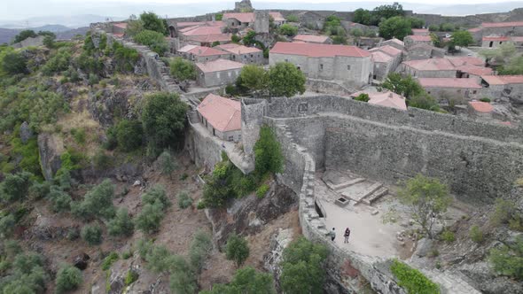 Ramparts surrounding historical village of Sortelha, Portugal; aerial pan