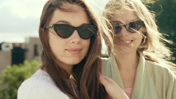 Two young beautiful women posing outdoors 