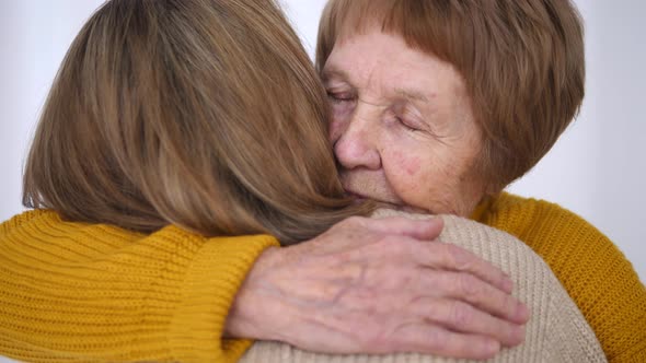 Daughter And Senior Mother Hugging. Close-Up